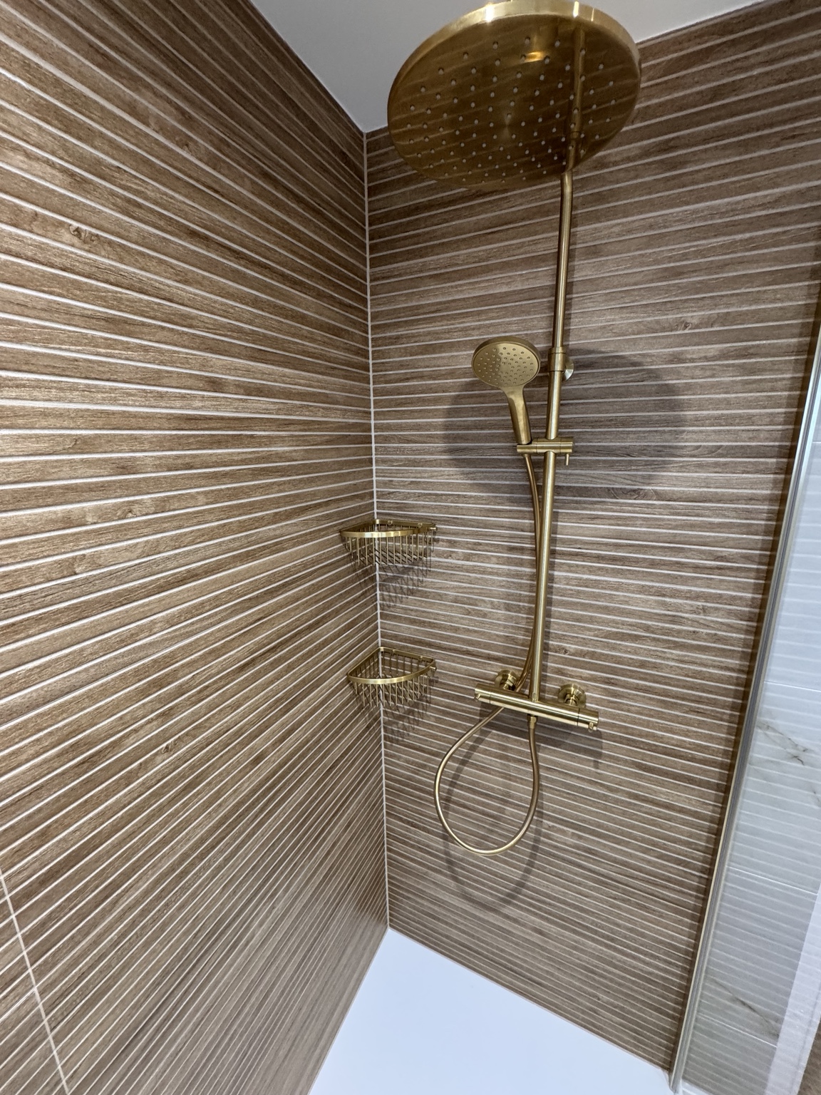 Brass rainfall shower and corner shelving